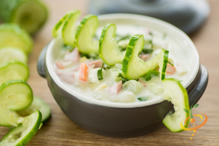 Fresh cucumber salad with sliced Muncher cucumber in a bowl on wooden surface
