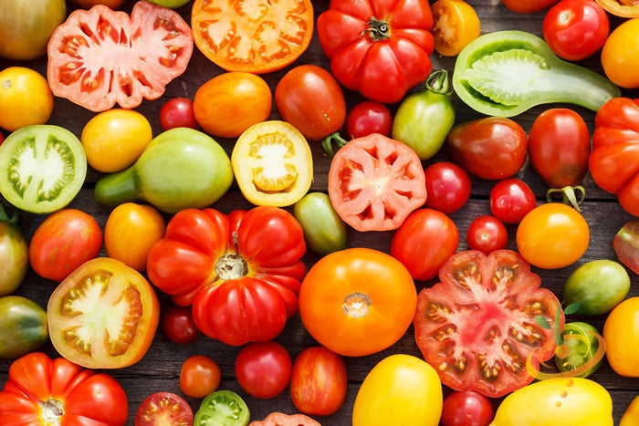 Heirloom Rainbow Mix indeterminate tomato seeds from SeedsNow, showcasing colorful ripe tomatoes and green foliage.