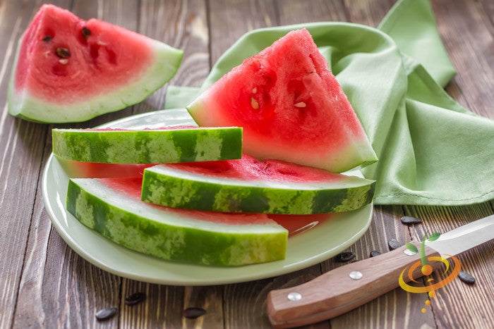Sliced bright red sweet watermelon on white plate with wooden table and knife showcasing All Sweet Watermelon seeds product