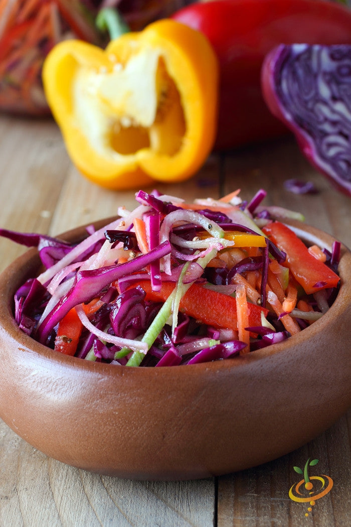 Fresh coleslaw with red Acre cabbage, bell peppers, and carrots in a wooden bowl