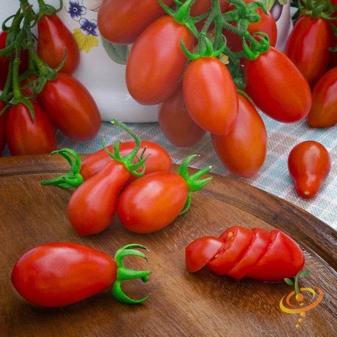 Red Pear Tomato Seeds | Red Pear Tomato clusters and sliced fruit on wooden board