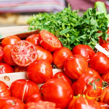 Fresh VR Moscow Tomatoes with vibrant red color and green herbs in background