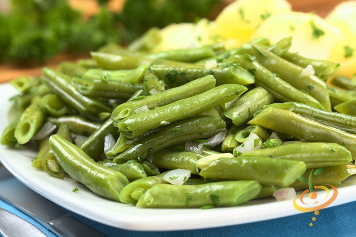 Blue Lake bush bean seeds from SeedsNow, showing small green bean seeds on a white background.