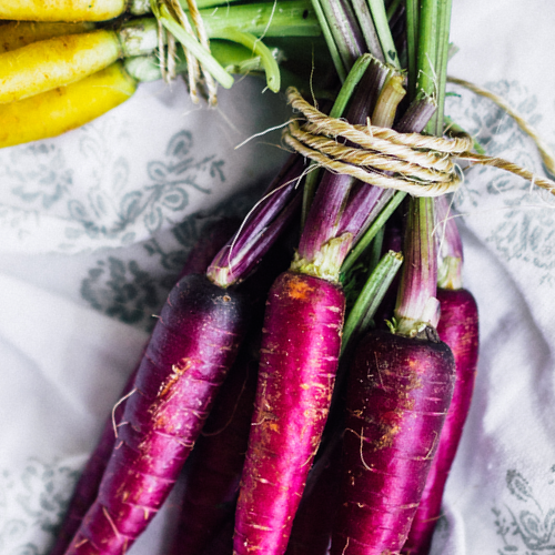 Purple Cosmic Carrot seeds from SeedsNow, 7-inch long vibrant carrots, shown in a close-up image.