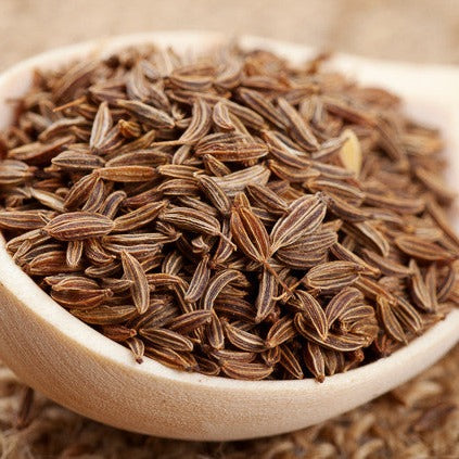 Close-up of fresh Caraway seeds in a glass jar, showcasing the aromatic seeds used in cooking and baking.